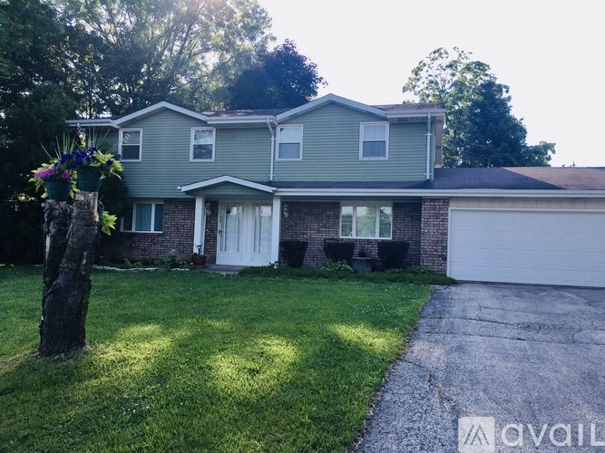 A house with a white door and windows is surrounded by green grass.