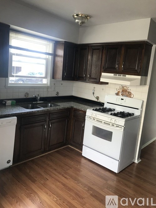 A kitchen with white appliances and wooden cabinets.