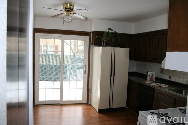 A kitchen with a white fridge and a ceiling fan.
