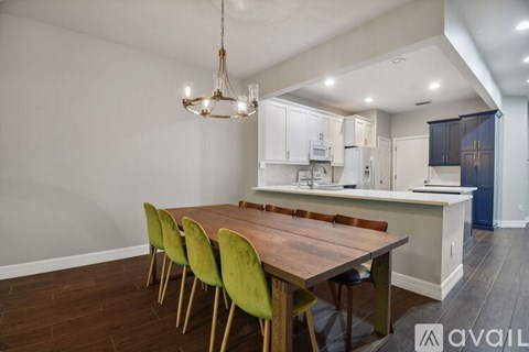 A kitchen with a table and chairs in front of it.
