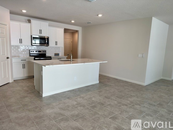 A kitchen with a white island in the middle of the room.