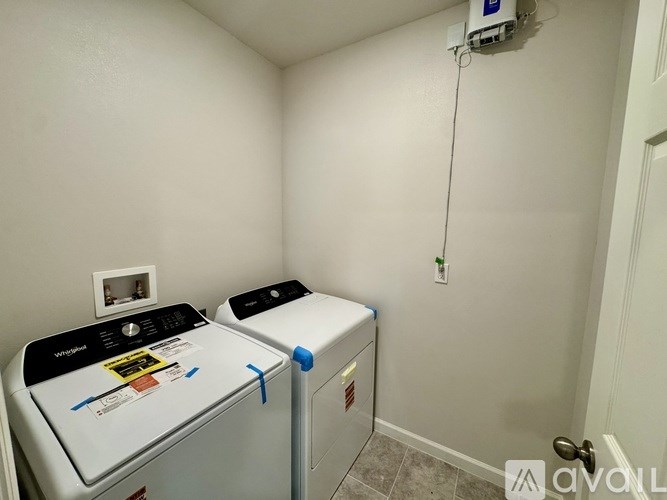 A room with two washing machines and a wall-mounted water heater.
