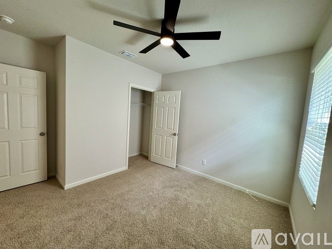 A room with a ceiling fan and two doors.