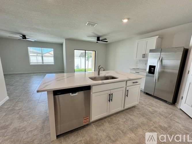 A kitchen with a sink, stove, and refrigerator.