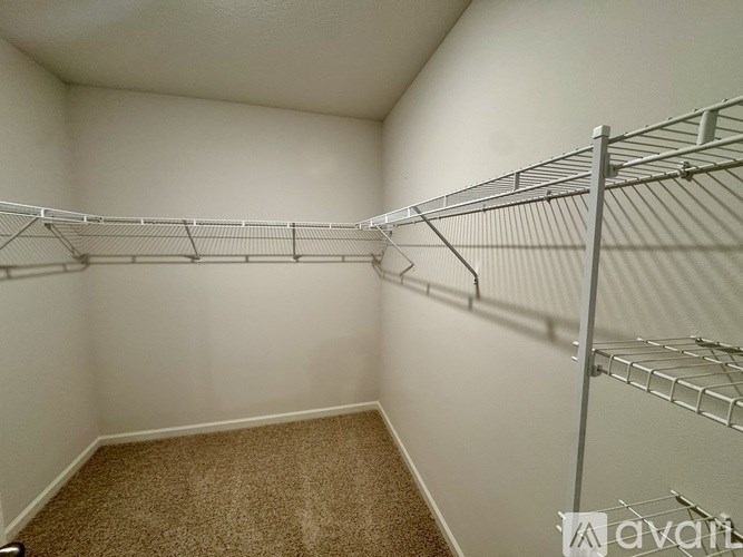 Empty room with metal shelving and carpeted floor.