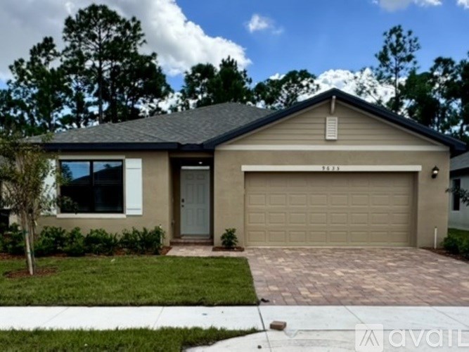 A house with a garage and a driveway in front.