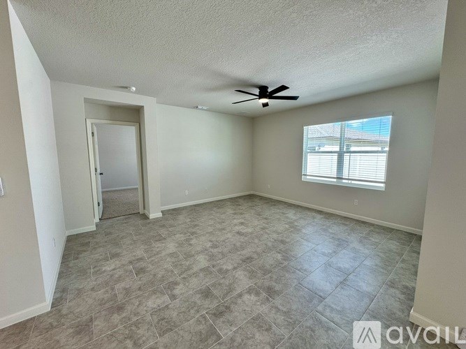A room with a ceiling fan and a window with blinds.