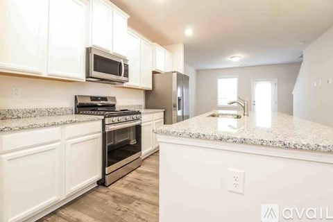 A kitchen with white cabinets and a granite countertop.