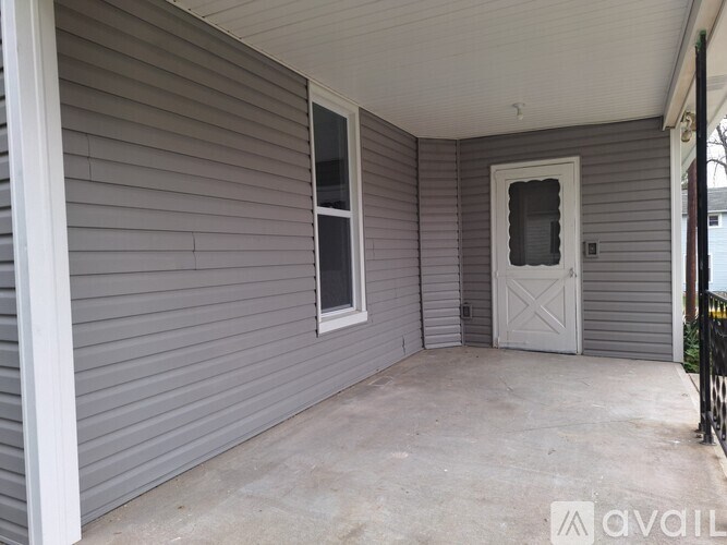 A grey house with a white door and window.