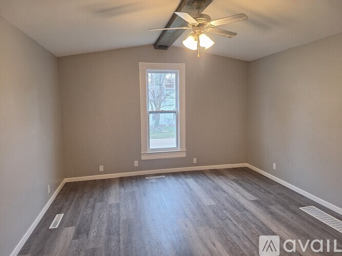 A room with a window and a ceiling fan.