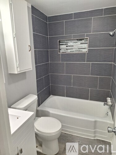 A bathroom with a toilet, sink, and bathtub.