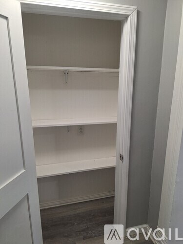 A white closet with a hanging rod and a door.