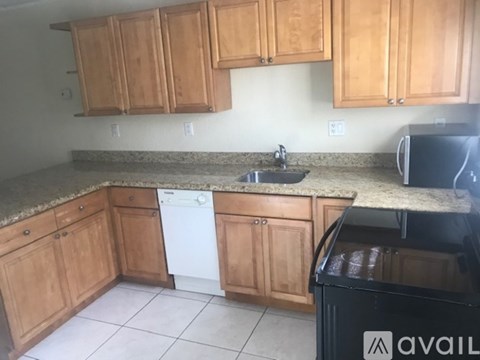A kitchen with wooden cabinets and a granite countertop.