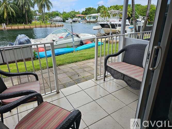 A balcony with a chair and a table overlooking a body of water with boats.