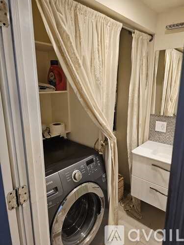 A small laundry room with a washer and dryer.