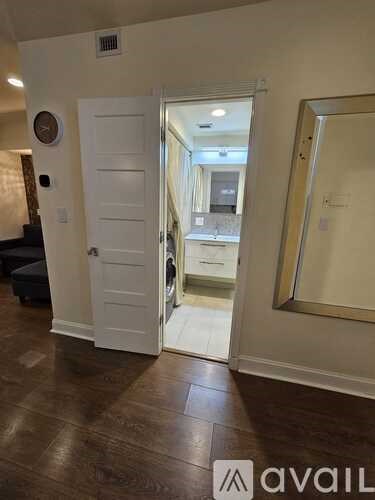 A room with a white door and a clock on the wall.
