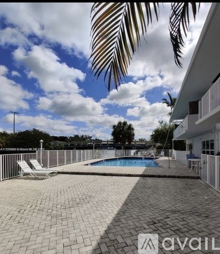 A patio with a pool and a palm leaf.
