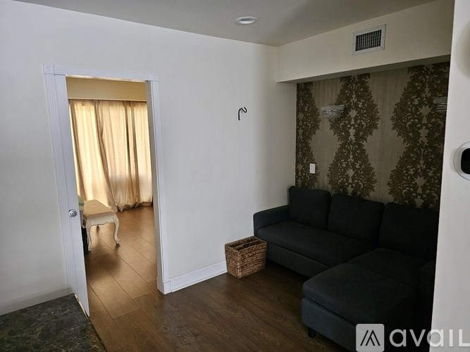 A living room with a black couch and a small table.