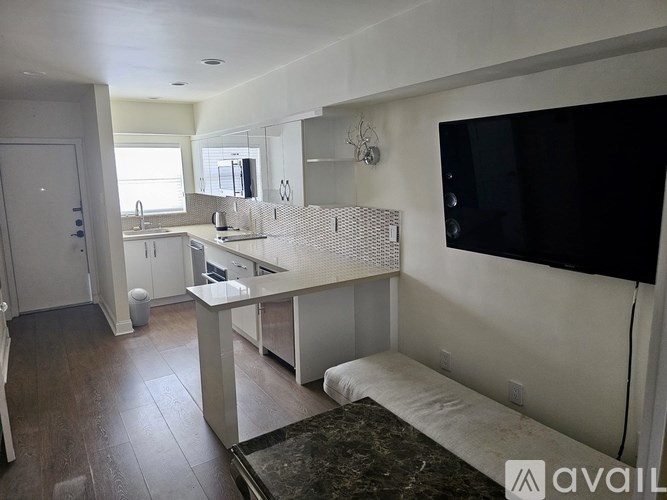 A kitchen with white cabinets and a black countertop.
