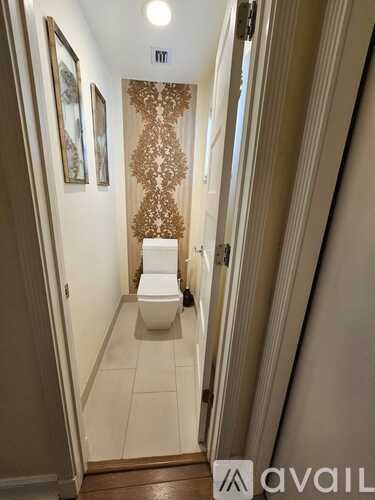 A bathroom with a toilet and a decorative wall hanging.