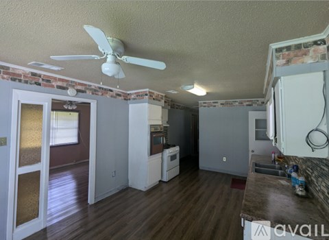 A kitchen with a fan and a fridge.