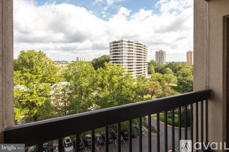 A balcony view of a cityscape with a tall building in the background.