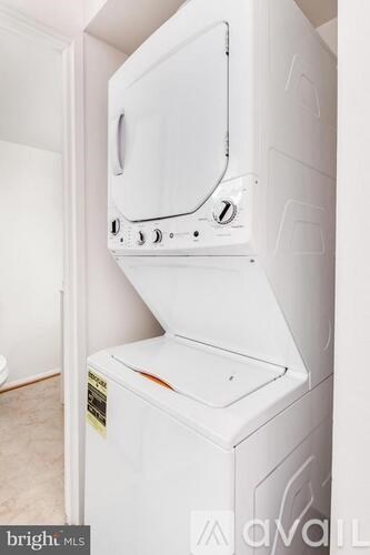 A white oven with a black handle is installed in a kitchen.