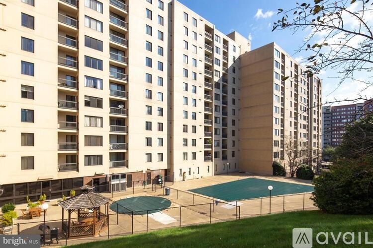 A large apartment complex with a pool in the courtyard.
