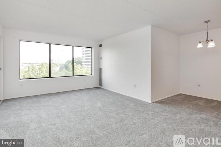 A large, empty room with a view of the city through the windows.