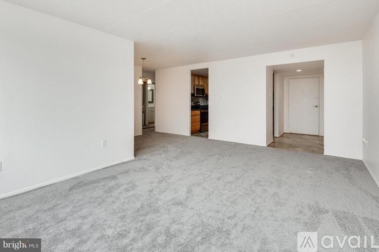 A large empty room with a carpeted floor and white walls.