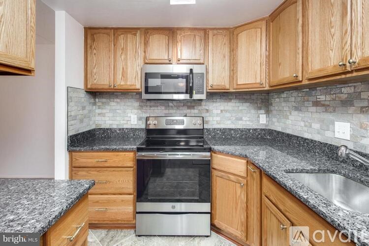 A kitchen with wooden cabinets and granite countertops.