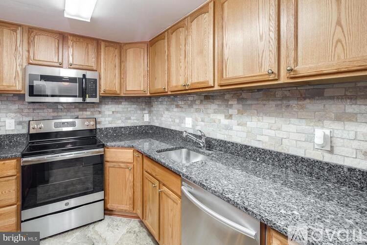 A kitchen with wooden cabinets and a granite countertop.