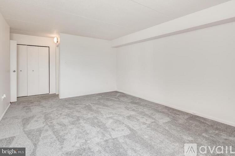 A room with a carpeted floor and a white door.