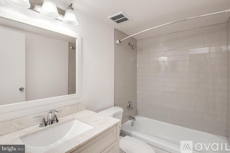 A bathroom with a white sink and tub.