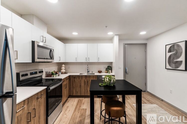 A kitchen with a black table and brown chairs.