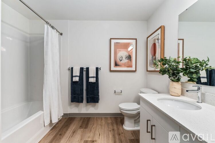 A bathroom with a toilet, sink, and a mirror.