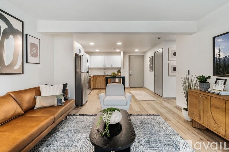 A modern living room with a brown leather sofa and a coffee table in the center.