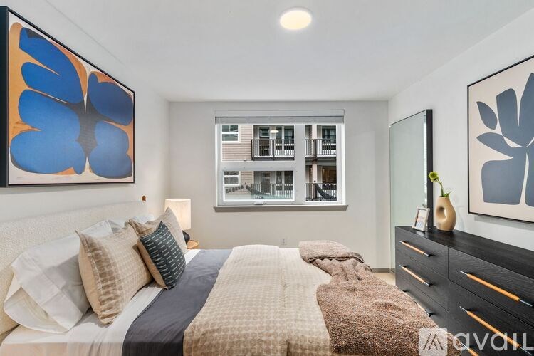 A bedroom with a large bed and a painting on the wall.