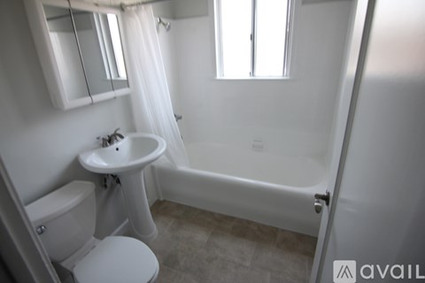 A white bathroom with a toilet, sink, and bathtub.