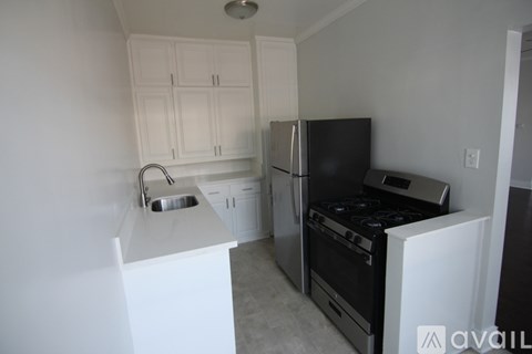 A kitchen with white cabinets and black appliances.