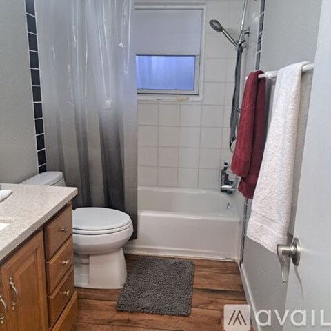 A bathroom with a toilet, a bathtub, and a shower curtain.