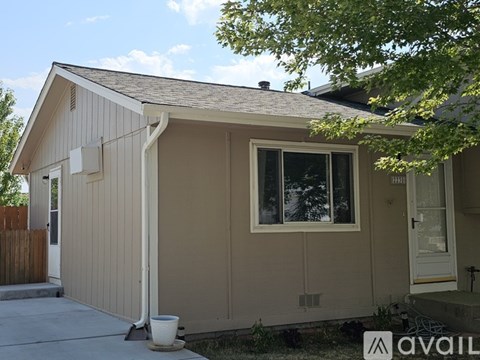 A small house with a brown roof and a white door is for sale.