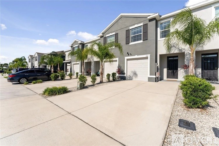 A row of houses with a black car parked in front of the first one.