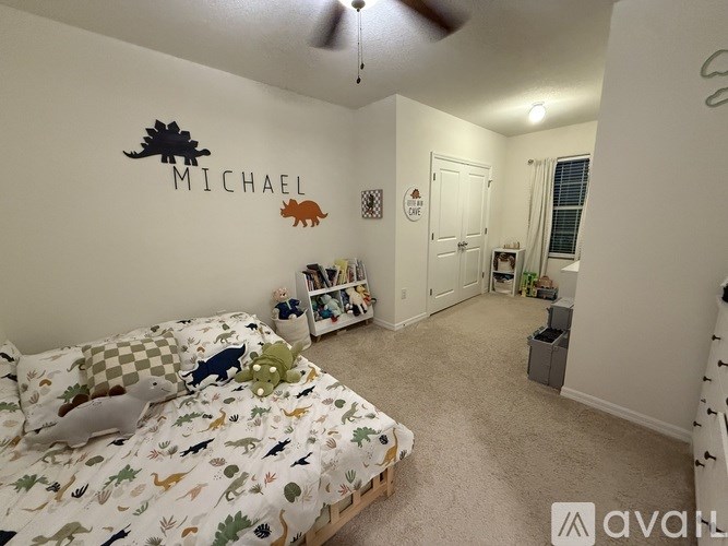 A bedroom with a bed, a dresser, and a wall decal that says "MICHAEL".
