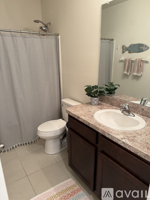 A bathroom with a toilet, sink, and shower.