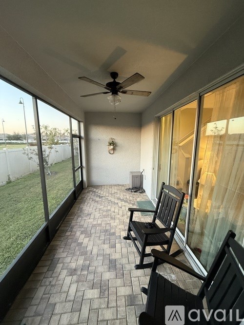 A patio with a bench and a ceiling fan.