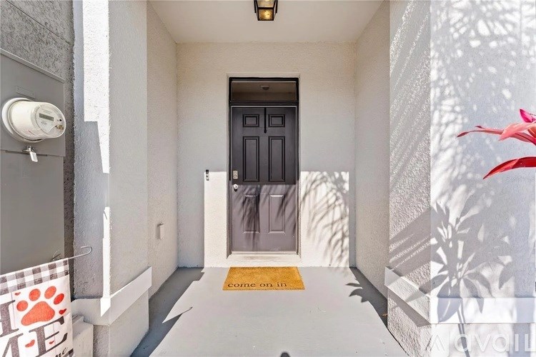 A black door is at the end of a white hallway.