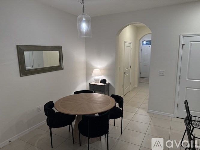 A dining room with a round wooden table and chairs.