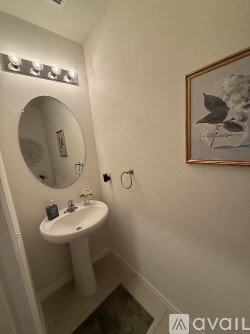 A bathroom with a sink, mirror, and lighting.