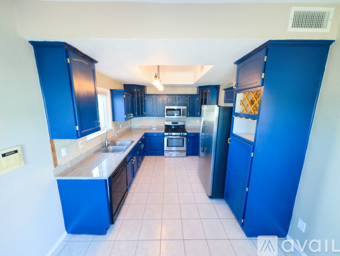 A kitchen with blue cabinets and appliances.